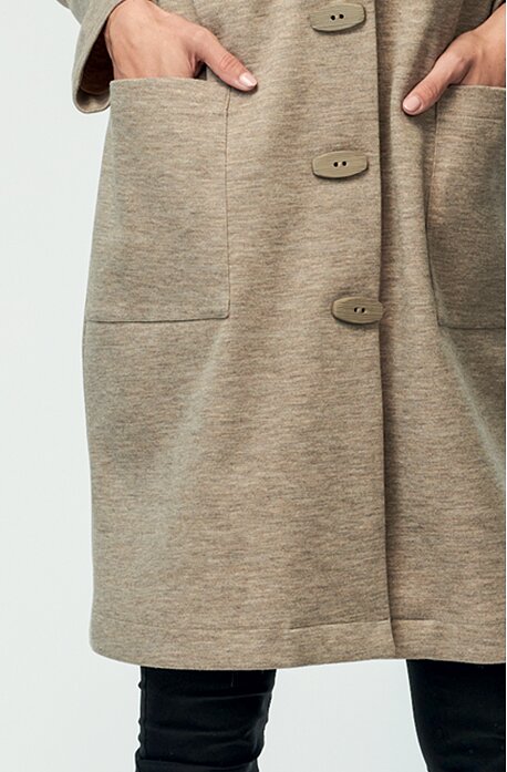 Volnější béžový dámský kabát s fazonou a kapsami 7632